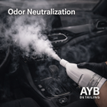 Gloved hand spraying mist in a car interior for odor neutralization, professionally detailed by AYB Detailing.
