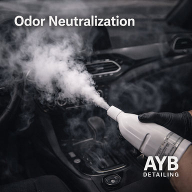 Gloved hand spraying mist in a car interior for odor neutralization, professionally detailed by AYB Detailing.
